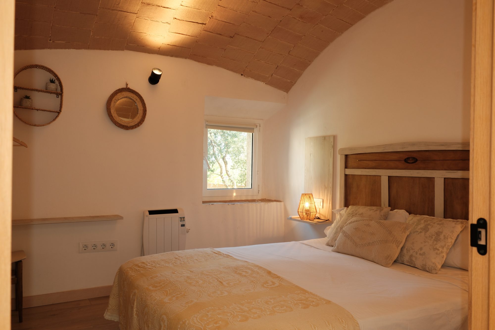 Habitació 2 — mirall de vímet i finestra al jardí