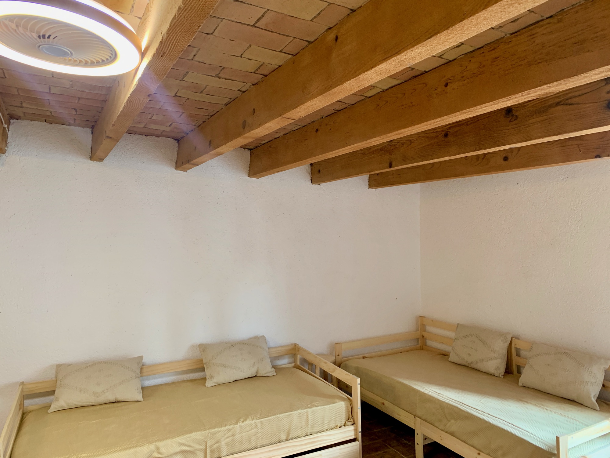 Habitació 4 — sostre amb bigues i maó vist