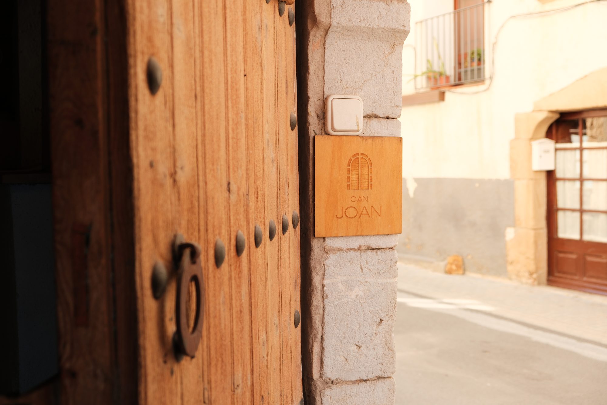 Detall de la porta de fusta amb la placa de Can Joan Empordà, al Carrer de la Mar